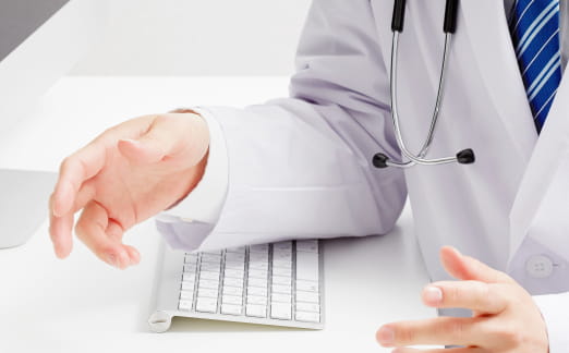 白衣を着た医師が机上で説明する様子