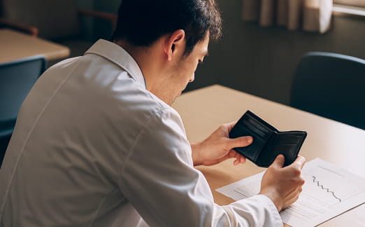 男性医師が書類を見ながらタブレット端末を操作している場面